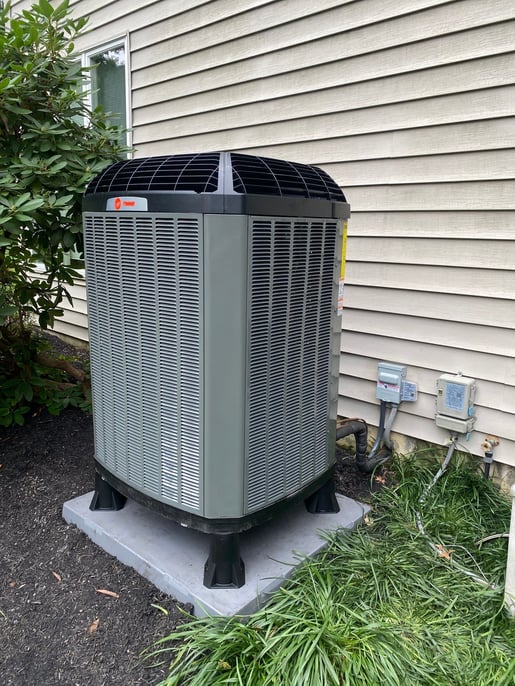 Outdoor cold-climate heat pump installed at a Doylestown, PA home, paired with a Trane propane furnace for dual-fuel heating and cooling.
