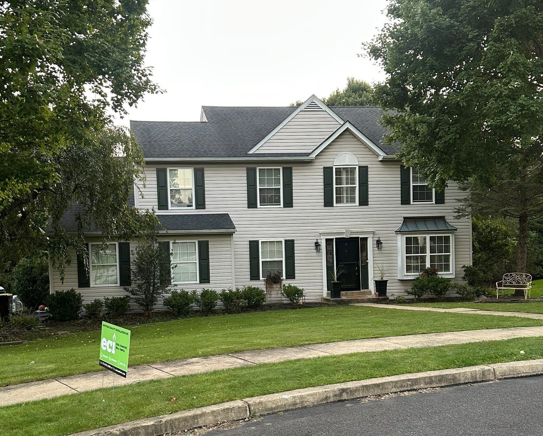 Front of the home with an ECI Comfort yard sign following a Ruud heating and cooling system replacement.