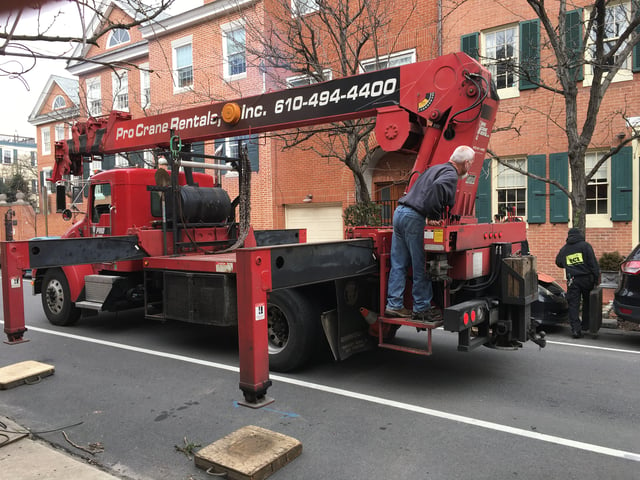 ECI using a crane to lift one of the three-ton units up to the second floor of the Philadelphia rowhome in the middle of the day. 