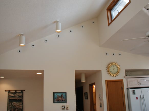 Ten high velocity units installed along the wall below the ceiling in living room. 