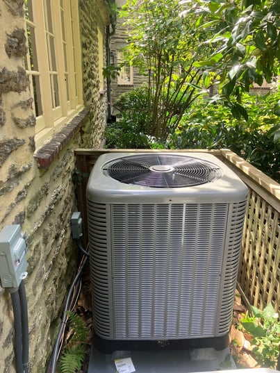 Outdoor Ruud two-stage heat pump paired with a Unico high-velocity system for second- and third-floor heating and cooling.